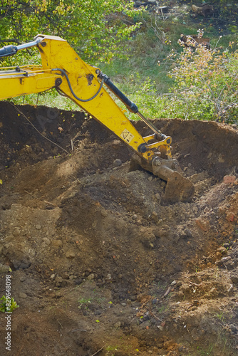  the excavator's bucket digs into the ground, clearing the way for new developments.
