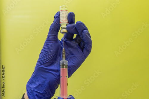 A nurse in blue gloves draws medicine into a syringe for an injection. Treatment in hospital. The doctor prepares a syringe for an injection. Therapeutic injections.