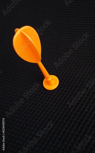Foto Orange velcro toy dart arrow on black soft pattern