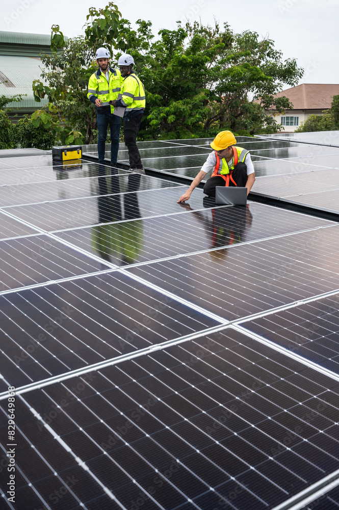 Vertical solar engineer team working at solar power station on roof Vertical solar engineer team working at solar power station on roof