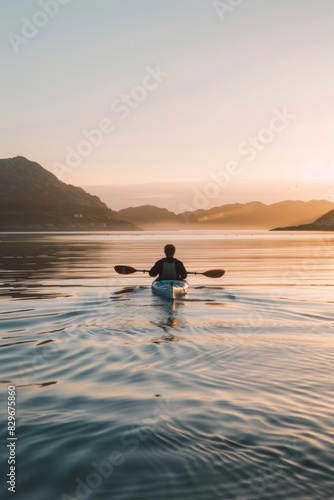 Serene Kayaker Enjoys Golden Sunset on Tranquil Mountain Lake