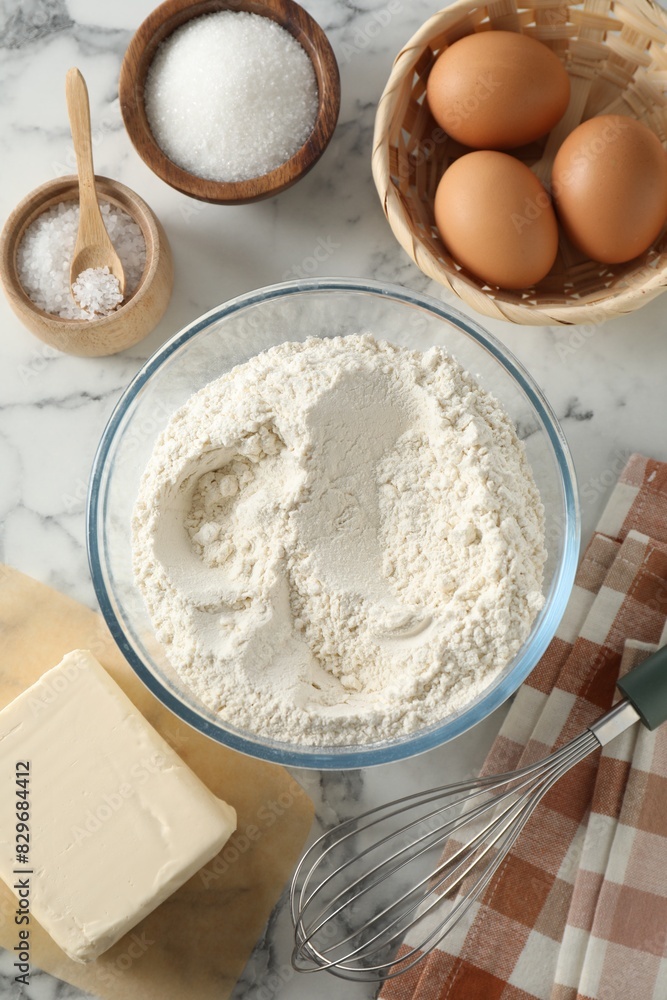 Making shortcrust pastry. Different ingredients for dough and whisk on white marble table, flat lay Making shortcrust pastry. Different ingredients for dough and whisk on white marble table, flat lay