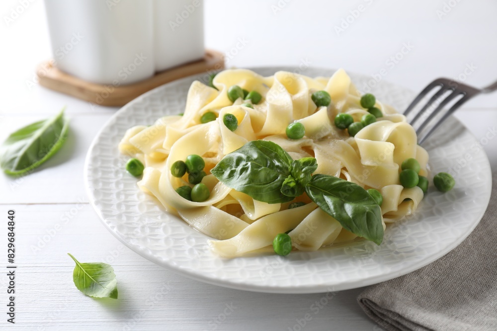 Delicious pasta with green peas served on white wooden table Delicious pasta with green peas served on white wooden table