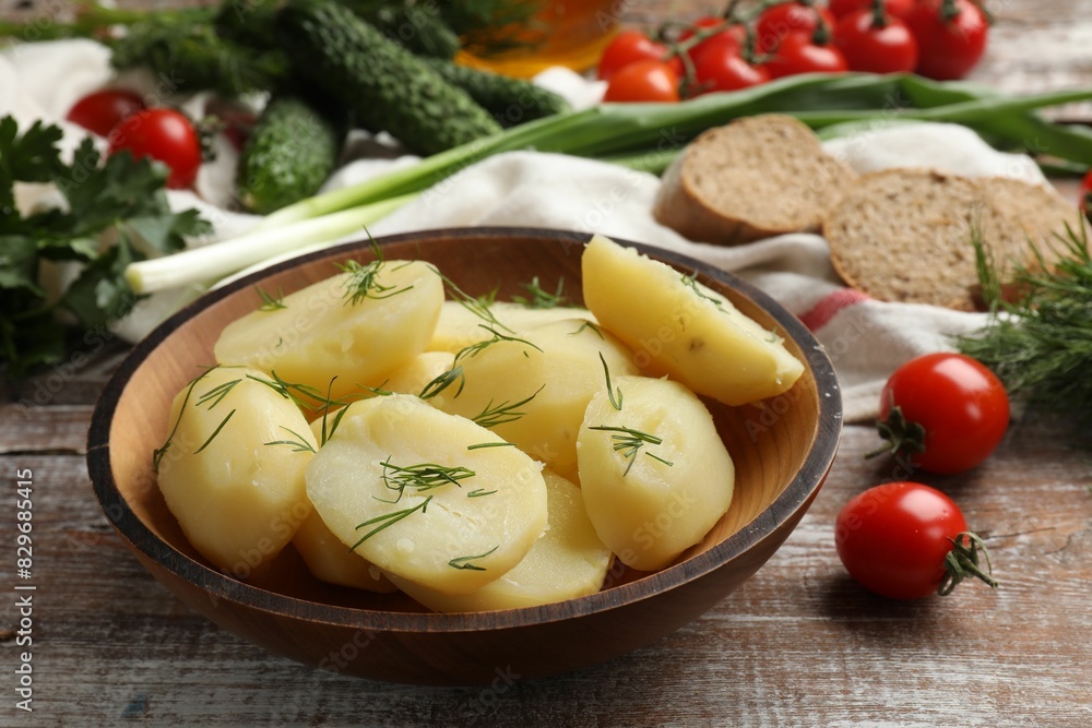 Young boiled potatoes with dill in bowl on wooden rustic table, closeup Young boiled potatoes with dill in bowl on wooden rustic table, closeup