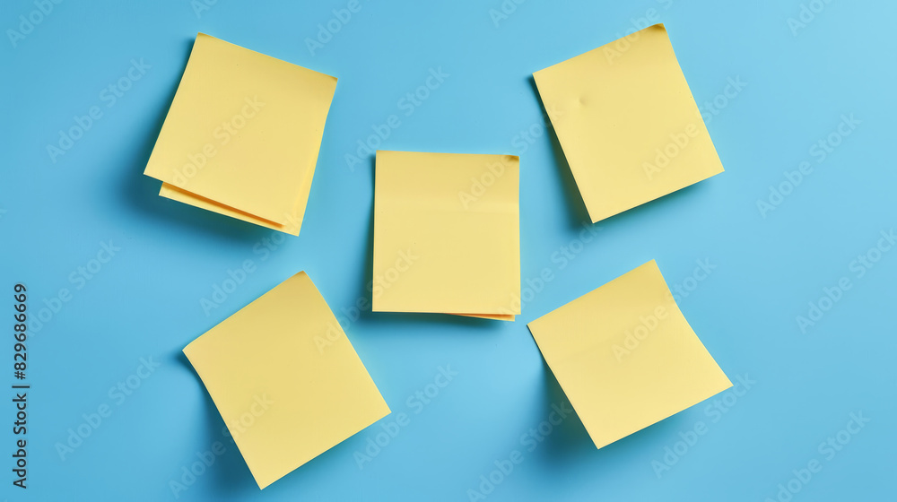 Five yellow blank post-it notes isolated on blue background Five yellow blank post-it notes isolated on blue background