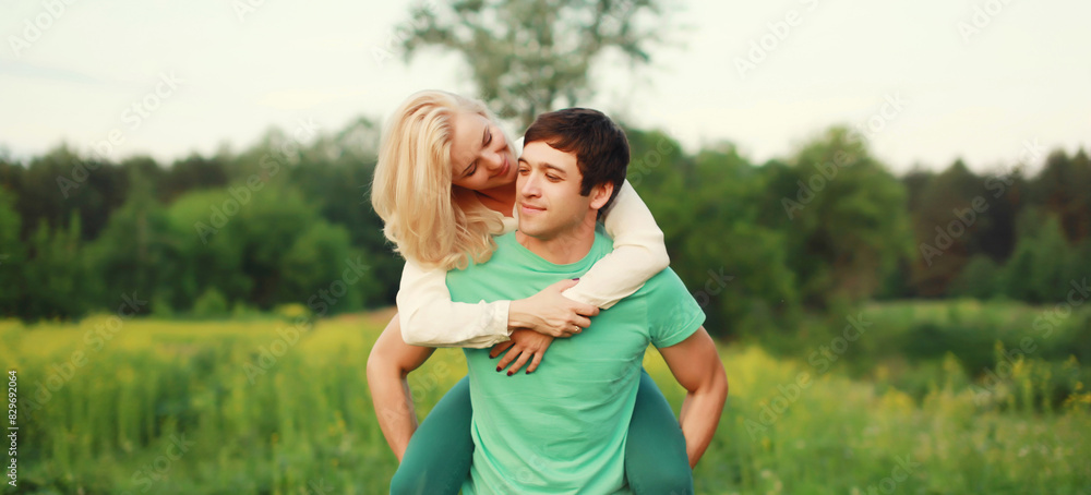 Portrait of beautiful happy smiling young couple in love together hugging in summer park