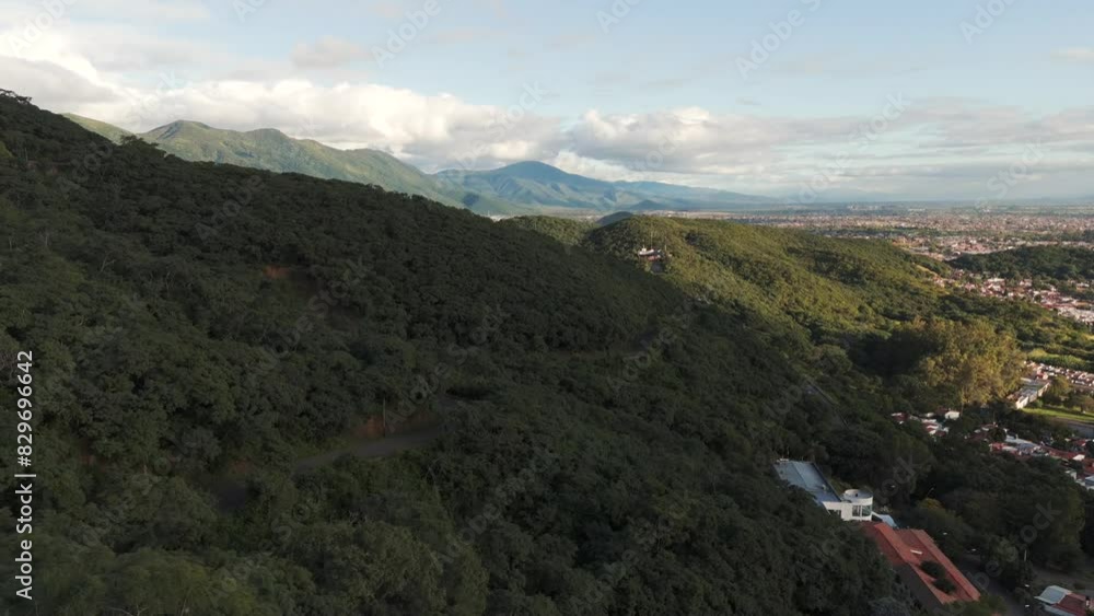 Low drone flight over tree tops on mountain side, mountains and cloud in distance sobre Salta Capital Low drone flight over tree tops on mountain side, mountains and cloud in distance sobre Salta Capital
