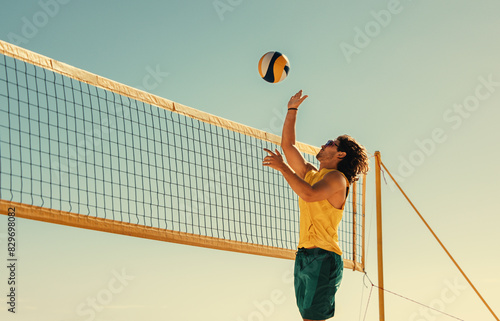 Mid-air volleyball jump by young australian athlete at coastal beach during summer games photo