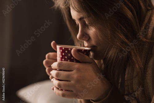 close-up of woman drinking tea from cup. Prevention of seasonal diseases photo