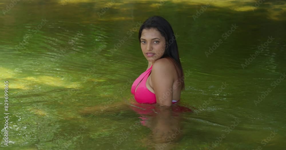 A young girl in a bikini enjoys the river on a sunny day on the tropical island of Trinidad. A young girl in a bikini enjoys the river on a sunny day on the tropical island of Trinidad.