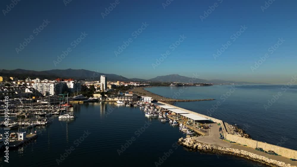 Pier of Estepona city and skyline in horizon, aerial ascend view Pier of Estepona city and skyline in horizon, aerial ascend view