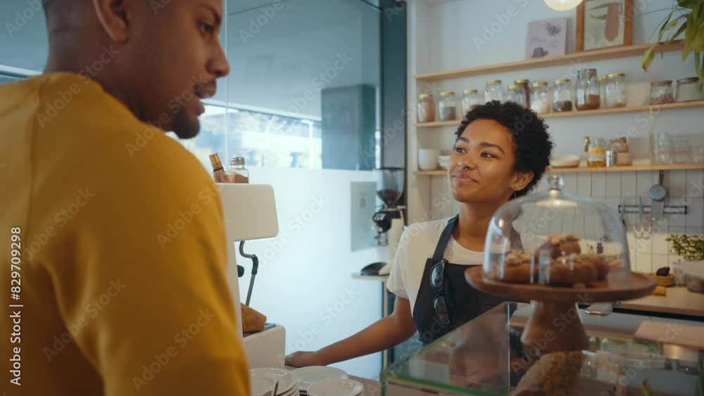 Cinematic image of waiters employees working in a nordic styled cafe. Waitress interact with a female customer. Client and barman conversating at the bar counter. Cinematic image of waiters employees working in a nordic styled cafe. Waitress interact with a female customer. Client and barman conversating at the bar counter.