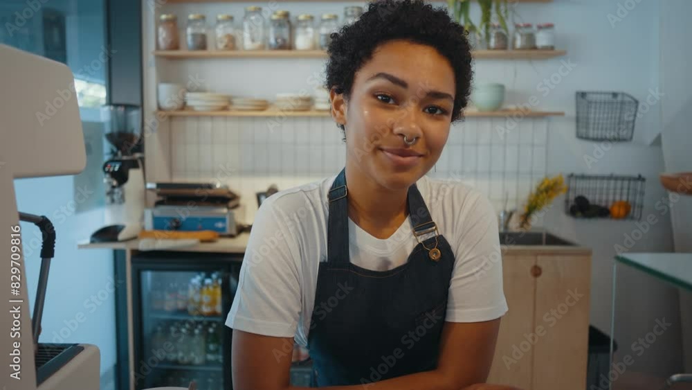 Beautiful woman working in a nordic styled cafe smiling in camera. Beautiful woman working in a nordic styled cafe smiling in camera.