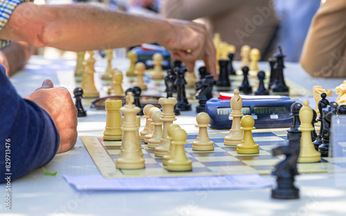 A group of people playing chess with a timer on the table