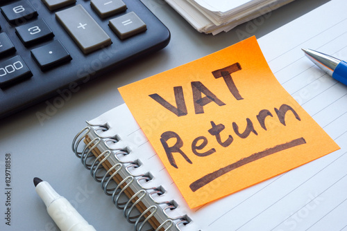 Open ledger and sticky note with words VAT return.