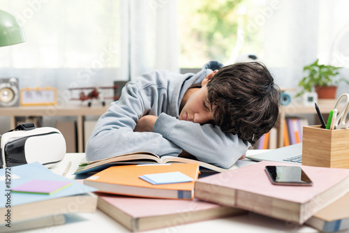 Fotografie Tired student sleeping at his desk