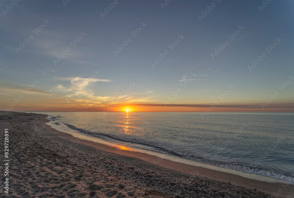 sunrise on the beach of Mojacar is presented with a golden sky and the sun's rays shining on the sea sunrise on the beach of Mojacar is presented with a golden sky and the sun's rays shining on the sea