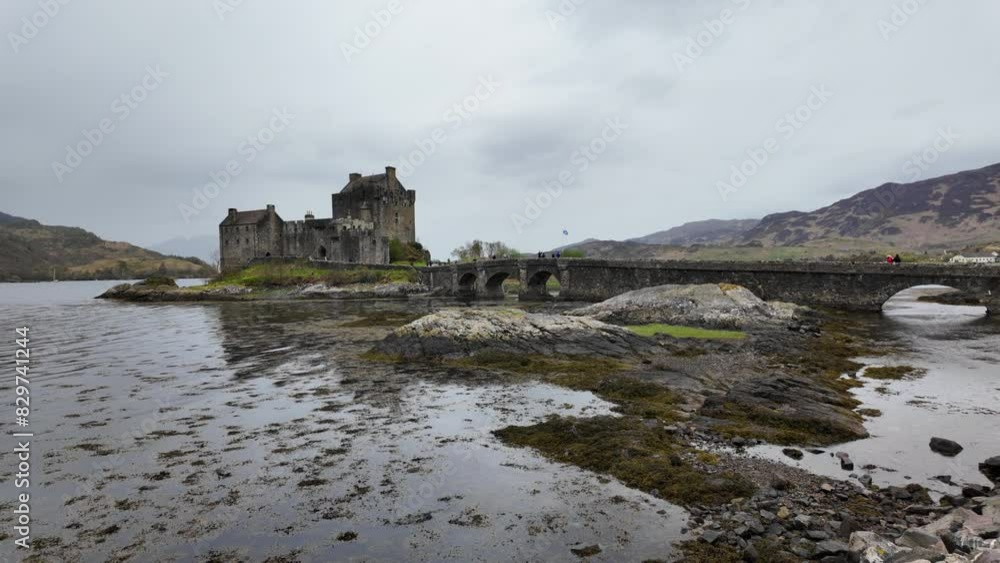 Historic Eilean Donan Castle by a misty loch and arched stone bridge in Scotland Historic Eilean Donan Castle by a misty loch and arched stone bridge in Scotland