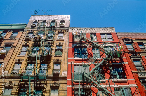 Eingescanntes Diapositiv einer historischen Farbaufnahme typischer Fassaden von Wohnäusern mit Außen- bzw. Feuerleitern, und zum Trocknen aufgehängte Wäsche in Manhattan, New York, USA