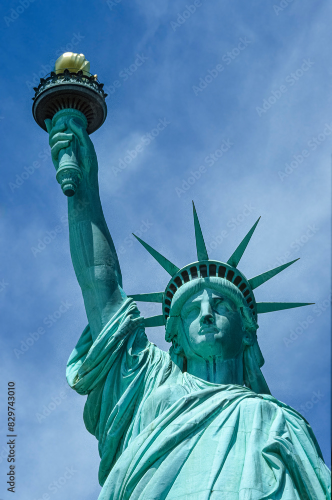 Fototapeta premium Eingescanntes Diapositiv einer historischen Farbaufnahme der Freiheitsstatue in New York in extremer Unteransicht bei sonnigem Wetter und leichter Bewölkung