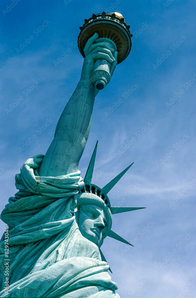 Fototapeta premium Eingescanntes Diapositiv einer historischen Farbaufnahme der Freiheitsstatue in New York in extremer Unteransicht bei sonnigem Wetter und leichter Bewölkung