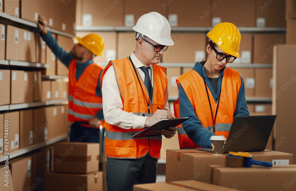 Warehouse workers checking orders on the laptop Warehouse workers checking orders on the laptop