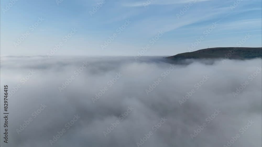 Aerial timelapse above the fog revealing mountain and blue sunny sky with clouds Aerial timelapse above the fog revealing mountain and blue sunny sky with clouds