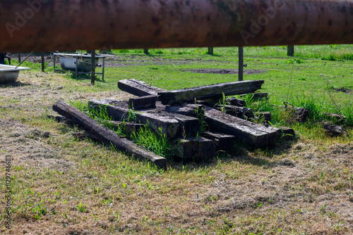 Pile of old used wooden train sleepers stacked in a horse pasture in Belgium photo