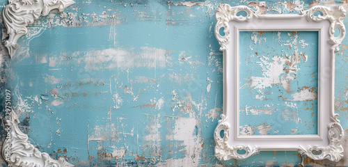 Small white baroque frame on faded blue wallpaper, showcasing shabby chic panoramic style. photo