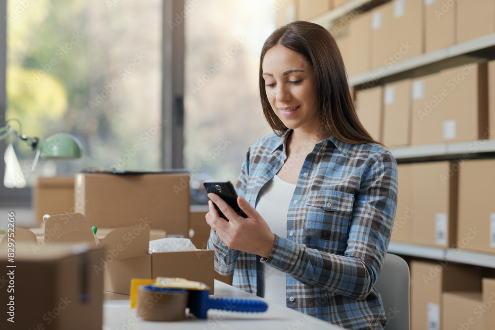 E-commerce business owner using a smartphone E-commerce business owner using a smartphone