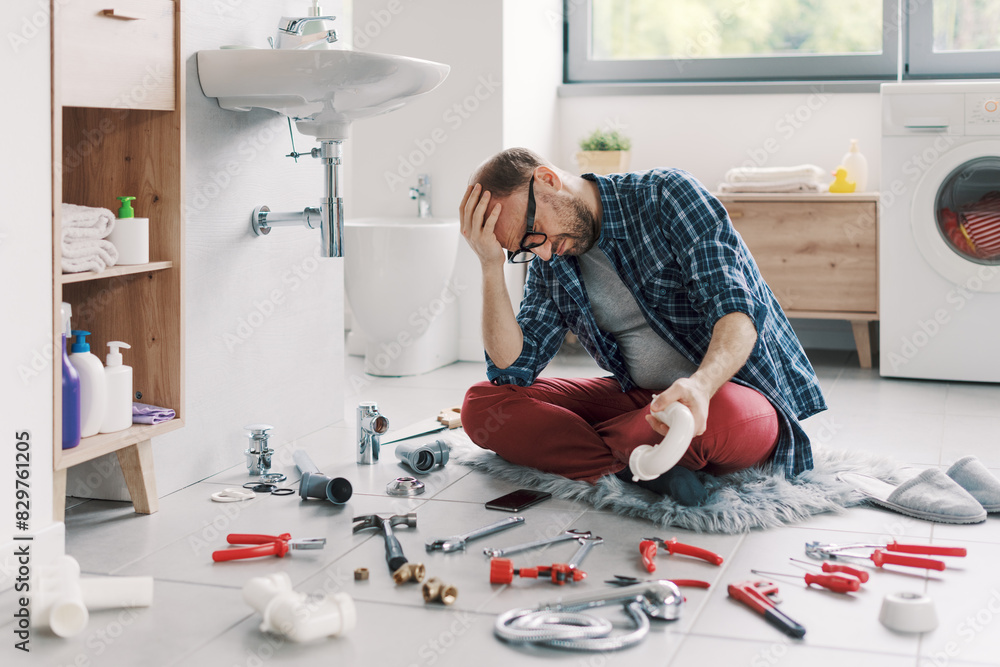 Confused man trying to fix the bathroom sink by himself Confused man trying to fix the bathroom sink by himself