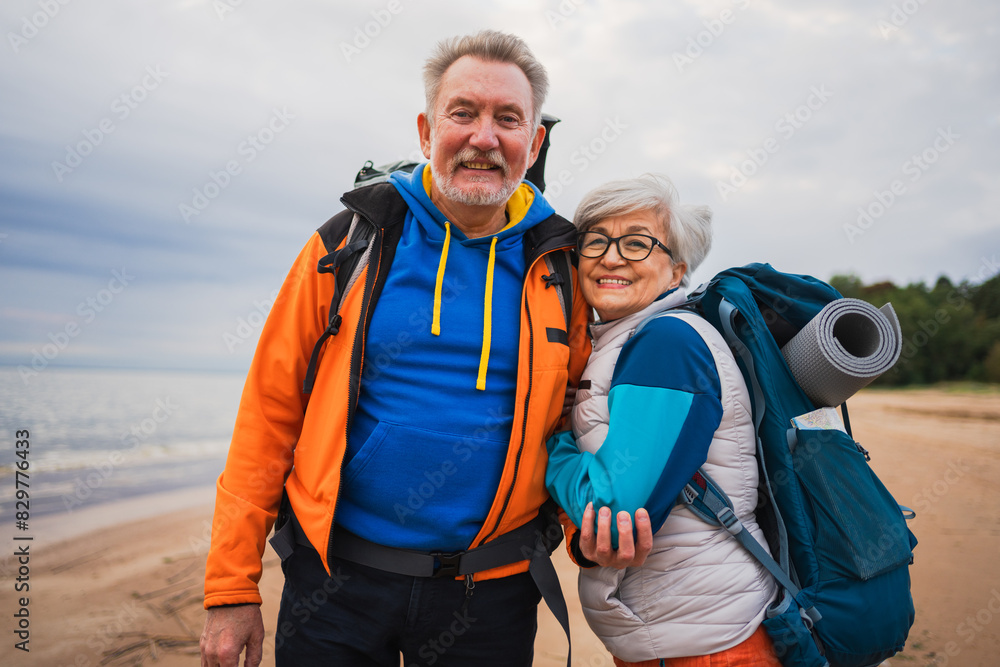 Hiking tourism adventure. Senior couple man woman enjoying outdoor recreation hiking on beach. Happy old people backpackers hikers enjoy walking hike trekking tourism active vacation beauty of nature