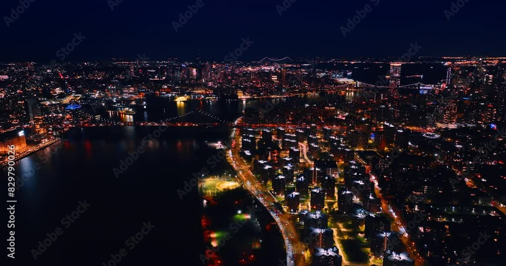 Night panorama of luminous New York at night. Flight over the East River revealing the spectacular bridges above it. Night panorama of luminous New York at night. Flight over the East River revealing the spectacular bridges above it.