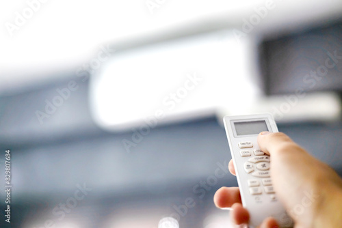 Modern Air Conditioner Unit With A Hand Holding A Remote photo