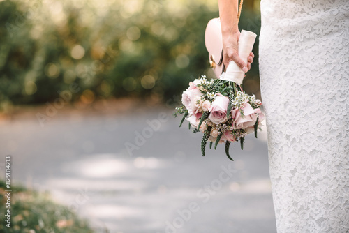 Hochzeitsstrauß und Brautkleid, Vorbereitung zur Trauung, Braut hält den Hochzeitsstrauß in der Hand