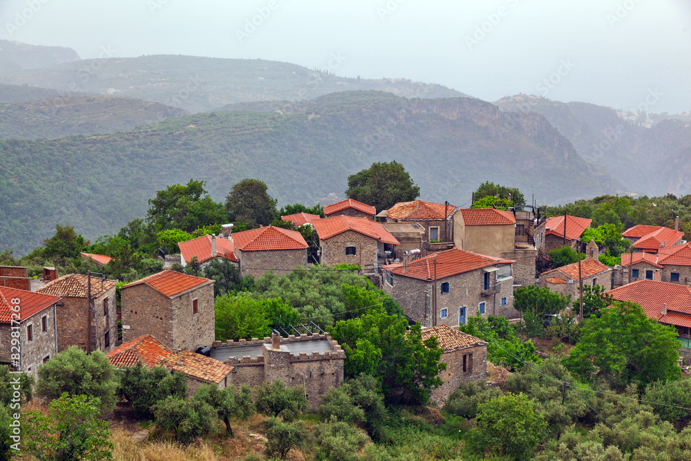Obraz premium Kato Tseria village, panoramic view of this traditional village in Peloponnese, Greece, with its stone-built houses and tile roofs, during slight rain. It lays right next to Vyros Gorge, in Messinia.