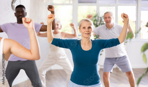 In fitness studio at group class  senior woman has fun and dances learn to move energetically to beat of music. Modern dance school  active lifestyle