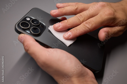 Wallpaper Mural A person is wiping a cell phone clean with a tissue Torontodigital.ca