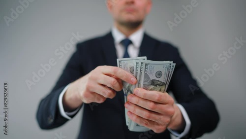 Formally dressed man carelessly throws US Dollar bills towards the camera photo