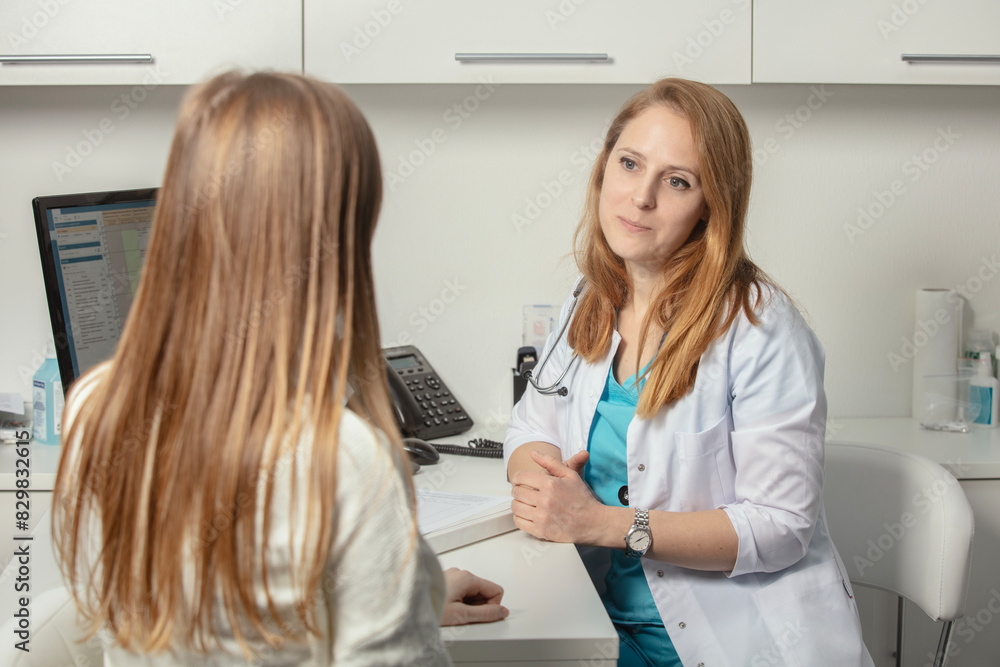 Fototapeta premium Patient visiting his doctor at hospital. Doctor woman at work in hospital excited and happy of consulting female patient. Physician controls medication history records and exam results. Medicine.