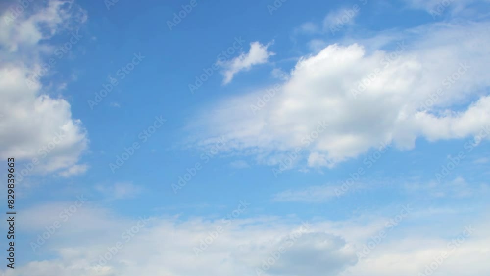Slow moving white cumulus clouds. Blue sky with several layers of clouds. Slow moving white cumulus clouds. Blue sky with several layers of clouds.