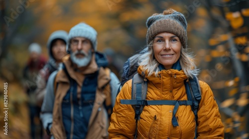 Smiling woman in yellow jacket enjoying a hike in autumnal woods with group in the background