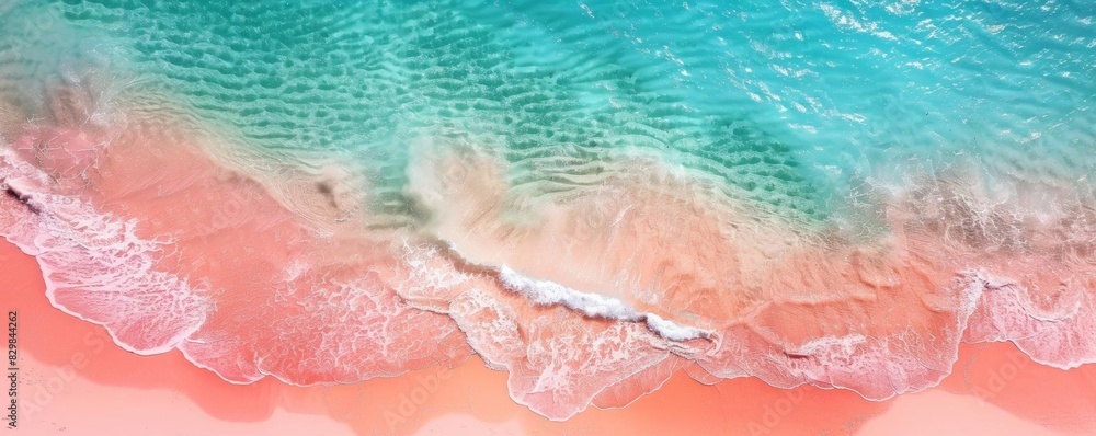 Aerial shot of a beautiful pastel pink sand beach merging with crystalclear turquoise waters