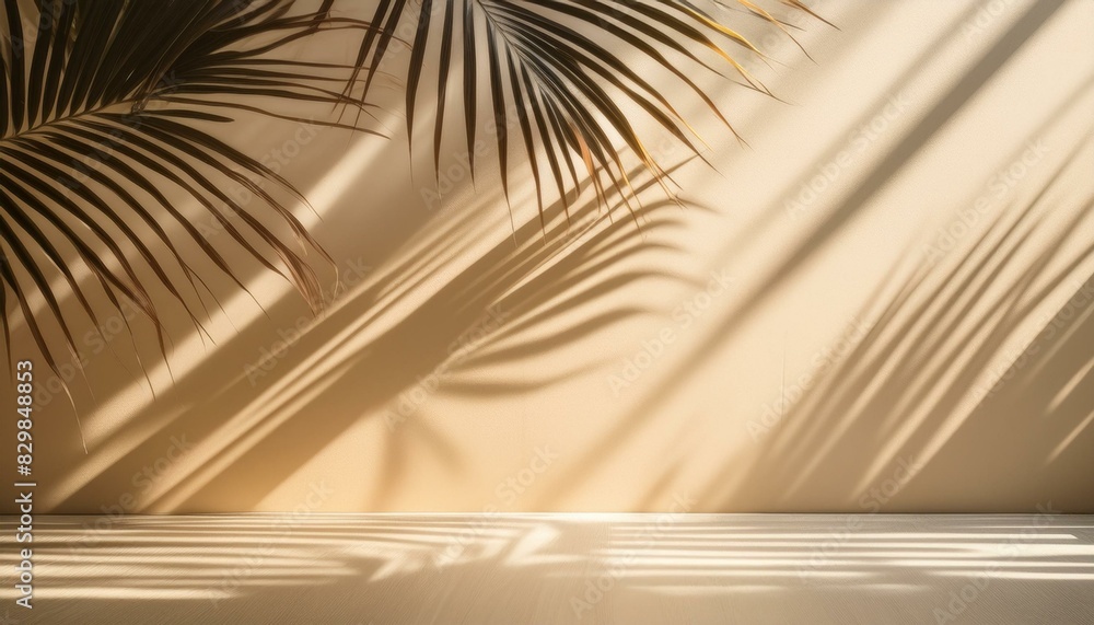 Fototapeta premium Blurred shadow of palm leaves on a light beige wall, soft sunlight creating delicate pattern