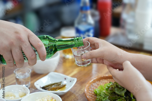 소주잔에 소주를 따라 주는 모습