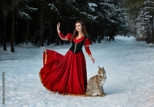Beautiful girl in medieval dress with lynx in forest. Fantasy portrait of girl from middle ages.