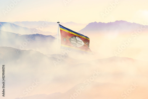 Eswatini flag disappears in beautiful clouds with fog. photo