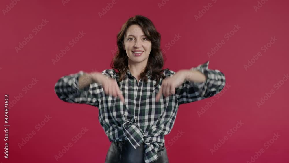 Mature woman pointing down to advertising area. Red background. Click subscribe Mature woman pointing down to advertising area. Red background. Click subscribe
