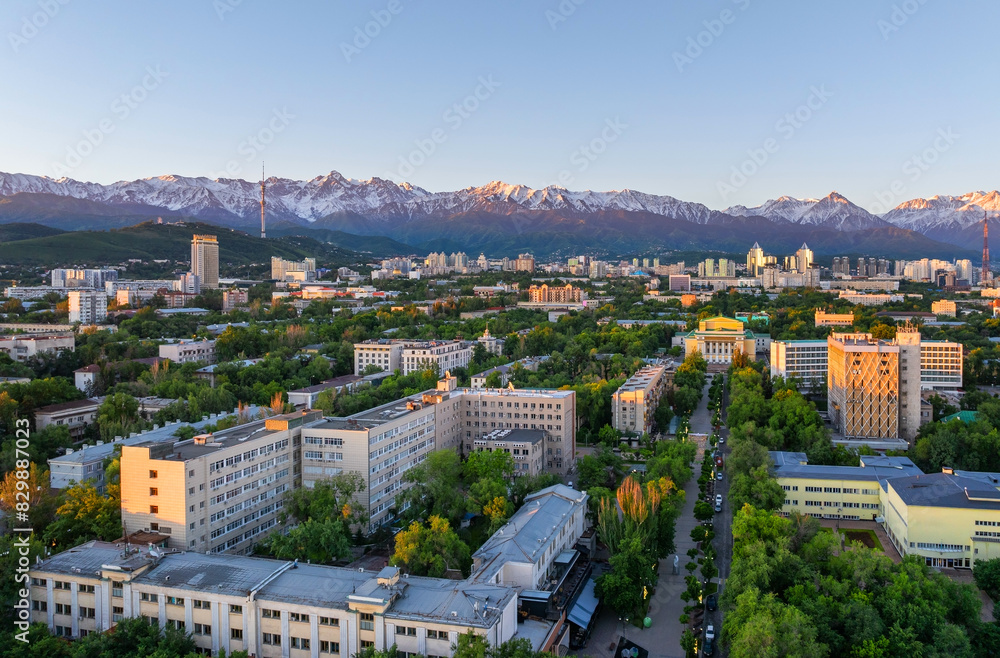 Fototapeta premium View from a quadcopter of the central part of the Kazakh city of Almaty on a spring morning against the backdrop of a mountain range
