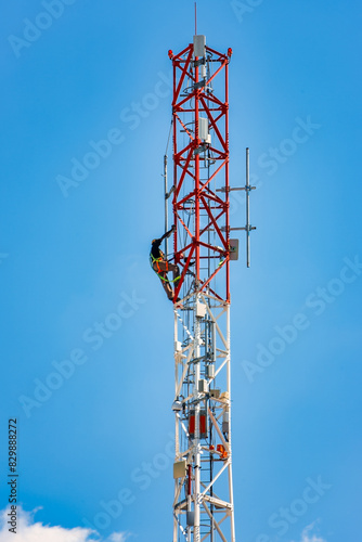 technician workers on a cellular tower antenna, clear sky background